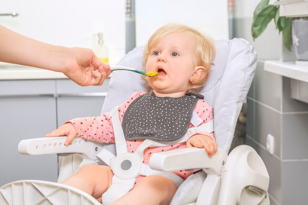 Schattig klein babymeisje in een keuken