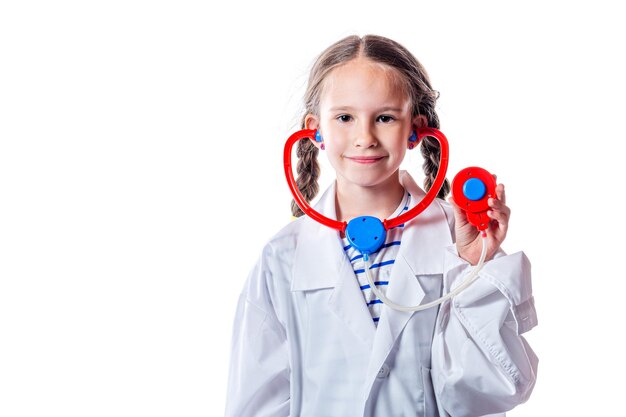 Schattig klein Europees meisje in dokter jas met speelgoed stethoscoop geïsoleerd op een witte achtergrond.