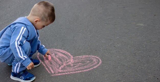 Schattig klein kind tekent buiten met krijt