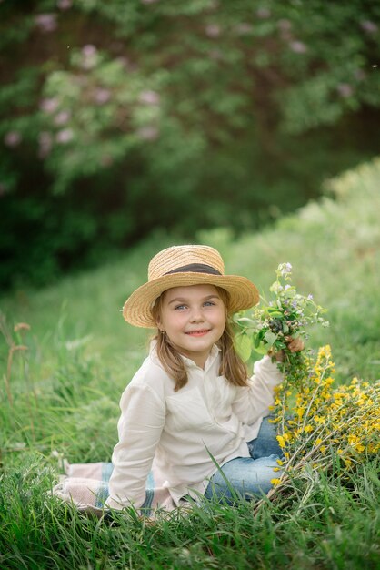 Schattig klein meisje 4 jaar oud op een picknick in een bloeiend bos in het voorjaar