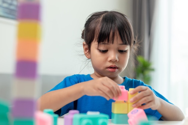 Schattig klein meisje dat blokken speelt in een lichte kamer