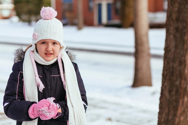 Schattig klein meisje dat plezier heeft op de winterdag, klein meisje dat in de winter op straat speelt