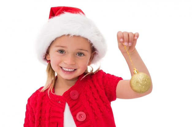 Schattig klein meisje dragen Kerst muts bedrijf bauble