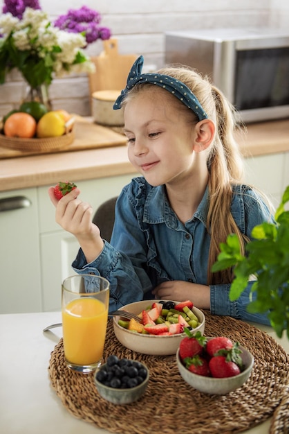 Schattig klein meisje eet fruitsalade