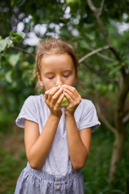 Schattig klein meisje eet groene appel in huis tuin buiten gelukkig kind