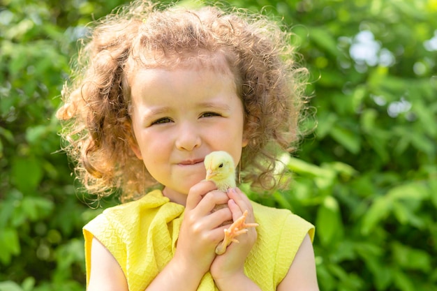 Schattig klein meisje en gele kip op handen vrolijk Pasen kinderen lente kind vakantie