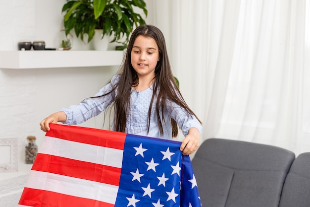 Schattig klein meisje en Usa vlag op de achtergrond.