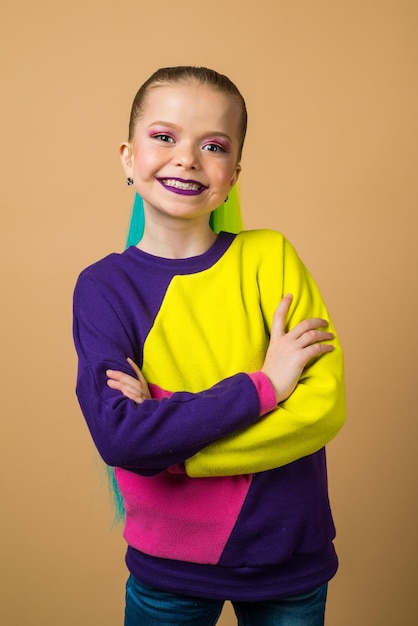 Schattig klein meisje in casual kleding poseren op camera studio portret van schoolmeisje met kleurrijke