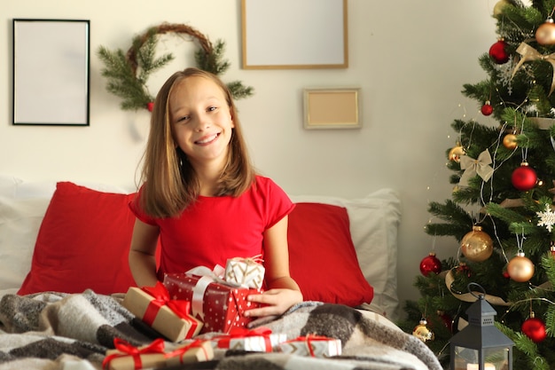 Schattig klein meisje in het kerstinterieur van het huis