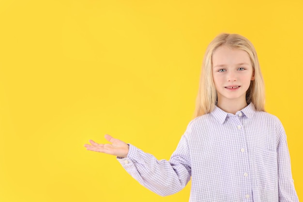 Schattig klein meisje in shirt op gele achtergrond