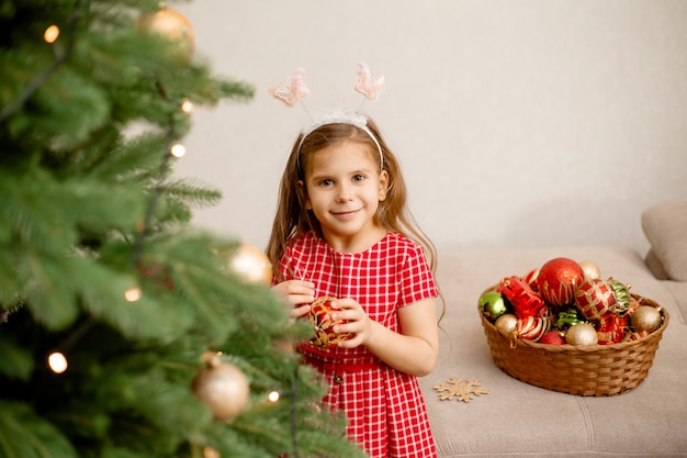 Schattig klein meisje kerstboom thuis versieren