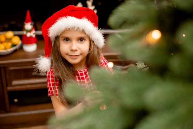 Schattig klein meisje kerstboom thuis versieren