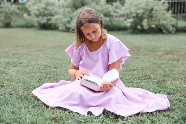 Schattig klein meisje leesboek buitenshuis. Zomerrust