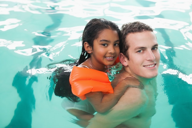 Schattig klein meisje leren zwemmen met coach