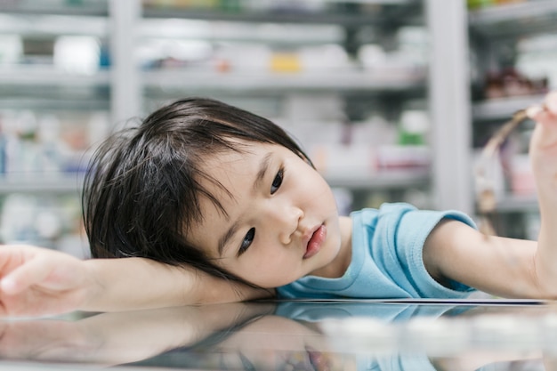 Schattig klein meisje leunend op tafel tegen onscherpe achtergrond