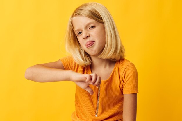 Schattig klein meisje met blond haar op basis van jeugd gele achtergrond