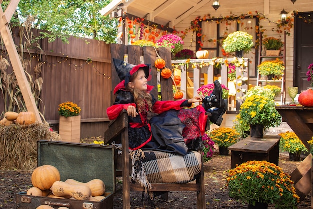 Schattig klein meisje met een Halloween-kostuum dat plezier heeft op een pompoenpleister op een mooie herfstdag