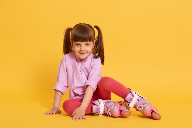 Schattig klein meisje met gelukkige gezichtsuitdrukking kijkt glimlachend naar de camera