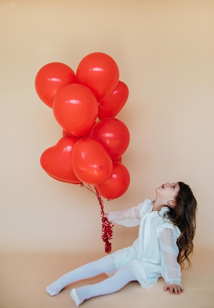 Schattig klein meisje met hartvormige ballonnen op Valentijnsdag familie liefdesgeschenken voor de vakantie