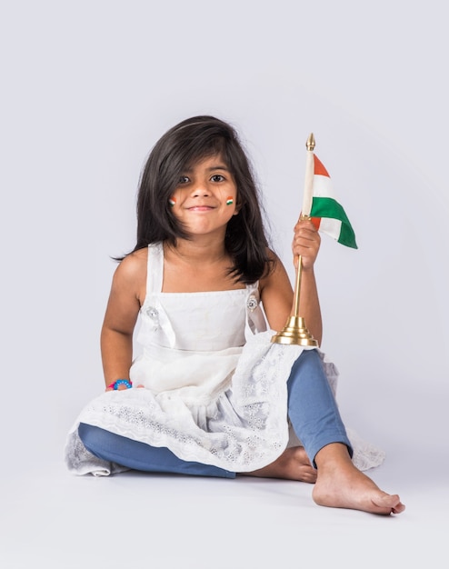 Schattig klein meisje met Indiase nationale driekleurige vlag, geïsoleerd op witte achtergrond. Geschikt voor Independence Day of Republic Day concept