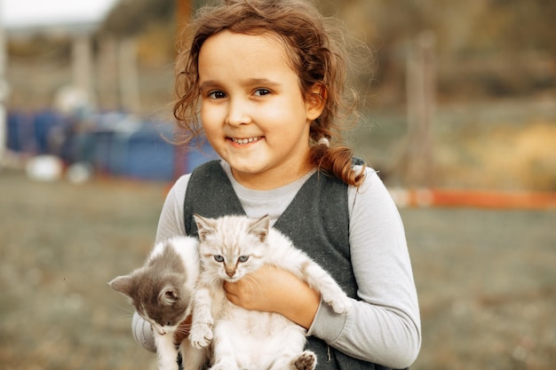 Schattig klein meisje met kittens katten buiten in de natuur Huisdier concept