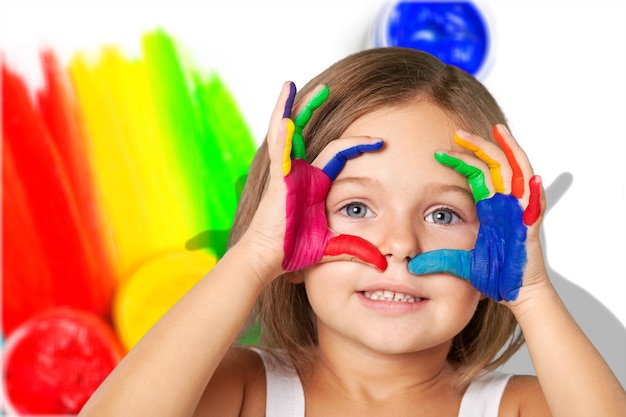 Schattig klein meisje met kleurrijke geschilderde handen op de achtergrond