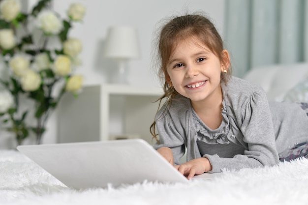 Schattig klein meisje met laptop thuis