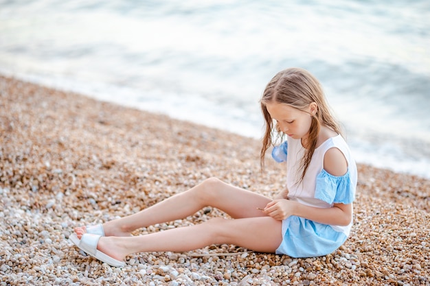 Schattig klein meisje op het strand tijdens de zomervakantie