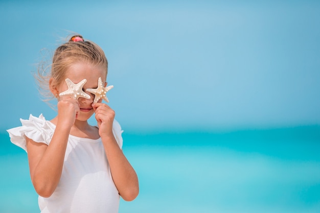 Schattig klein meisje op strand tijdens zomervakantie