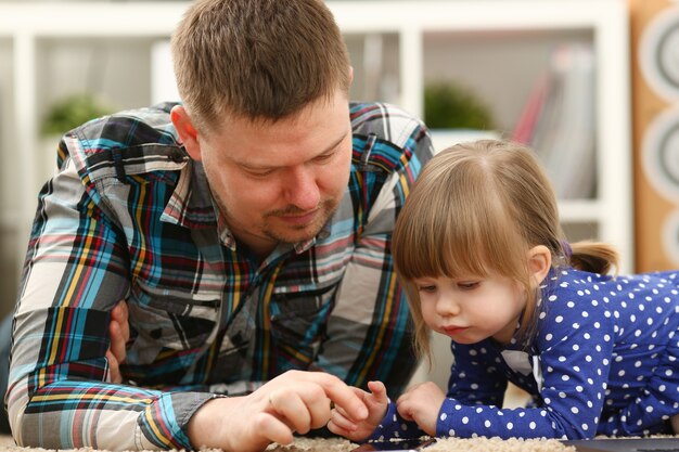 Schattig klein meisje op vloertapijt met papa mobiele telefoon bellen moeder portret