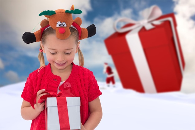 Schattig klein meisje rudolph hoofdband dragen tegen blauwe hemel met witte wolken