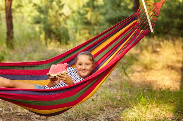 Schattig klein meisje rust in een gekleurde hangmat i