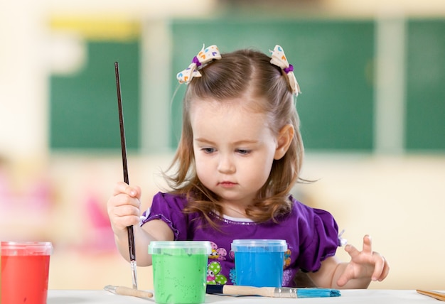 Schattig klein meisje schilderij op achtergrond