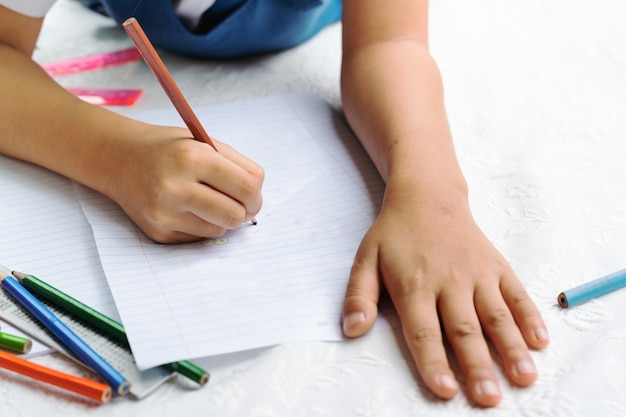 Schattig klein meisje schrijft boek besluit van lessen meisje vastleggen tekening van de afbeelding