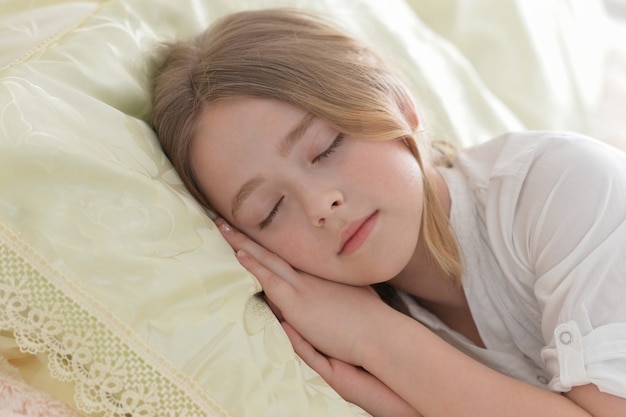 Schattig klein meisje slaapt in een bed