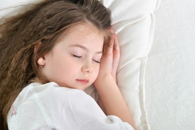 Schattig klein meisje slaapt in een bed