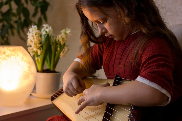 Schattig klein meisje speelt het gusli-psalterium