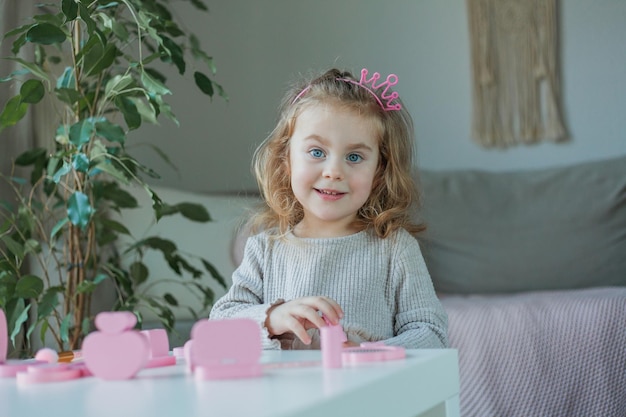 Schattig klein meisje speelt in een schoonheidssalon Mooi meisje van 3 jaar maakt thuis make-up met kindercosmetica