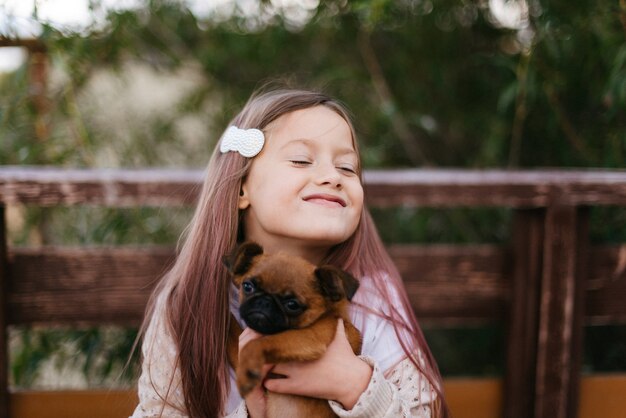 Schattig klein meisje speelt met kleine bruine hond