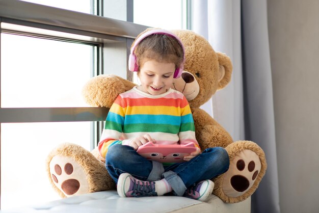 Schattig klein meisje tabletcomputer in haar handen te houden. Spellen. Kinderen gebruiken technologie.