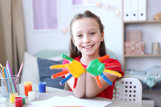 Schattig klein meisje tekent thuis verf