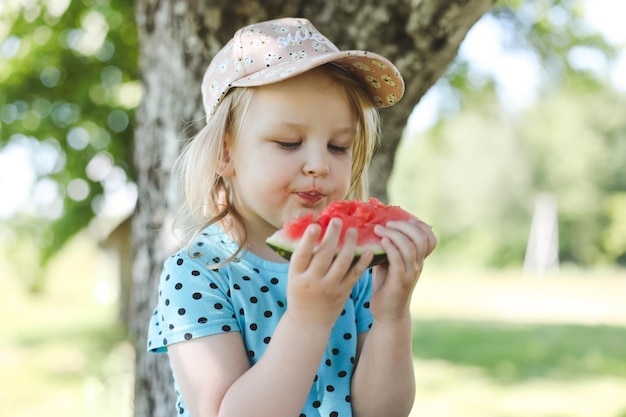 Schattig klein meisje watermeloen buiten eten in de zomer kind en watermeloen in de zomer