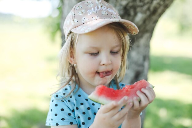 Schattig klein meisje watermeloen buiten eten in de zomer kind en watermeloen in de zomer