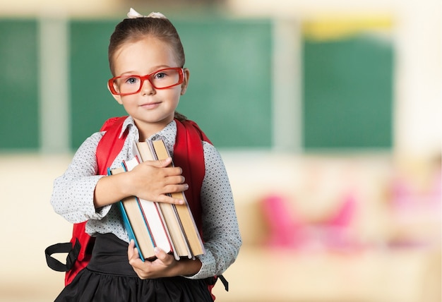 Schattig klein schoolmeisje in glazen op schoolbord achtergrond