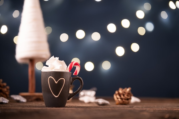 Schattig kopje koffie of warme chocolademelk met ophopende room in een kerstvakantie decoratie setting.