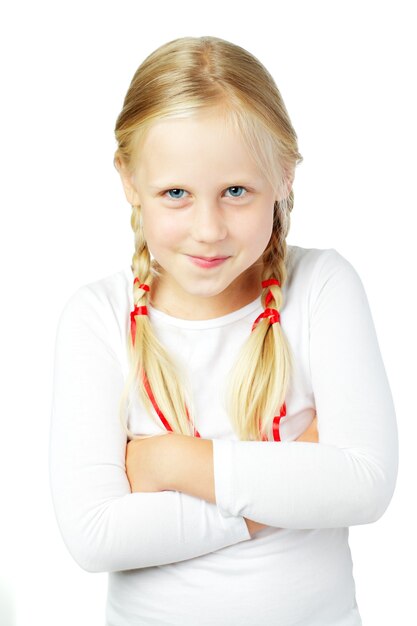 schattig lachend blond meisje met vlechten en gekruiste armen op witte achtergrond