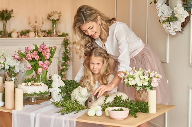 Schattig meisje en moeder spelen met konijn