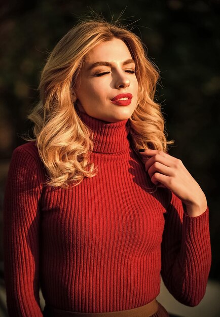 Schattig meisje geniet van de zonnige herfst laatste zonnestralen Modieuze kleding Vrouwelijkheid en tederheid Stijlvolle herfstoutfit Herfstmode Vrouw wandeling in herfstpark Gezellige breigoed Gebreide trui