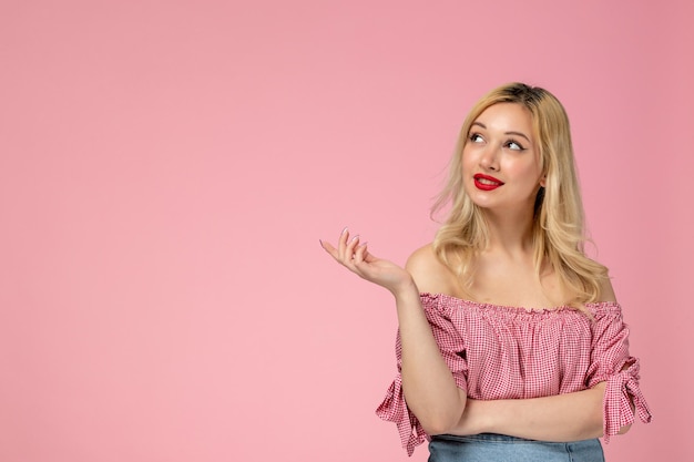 Schattig meisje, mooie jonge dame met rode lippenstift in roze blouse die ver weg kijkt en droomt