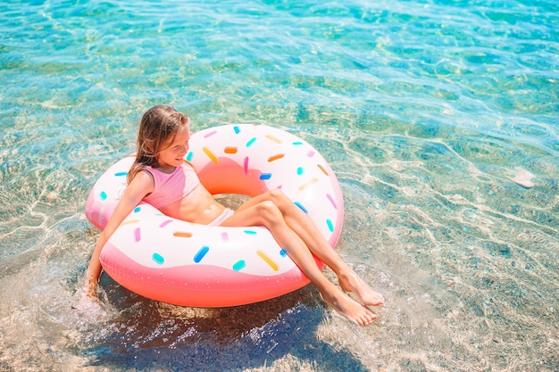 Schattig meisje op opblaasbare luchtbed in de zee